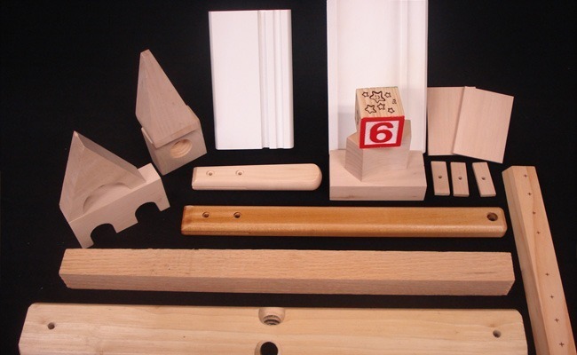 Assorted custom wood mouldings and dimension stock with drilled holes, painting, and cross boring for high-volume production.